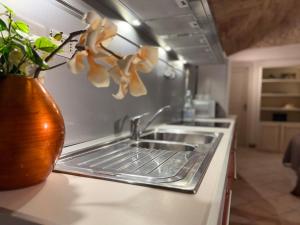 a kitchen counter with a sink and a vase with flowers at Charming Studio with Brick Vaulted Ceilings in Perugia