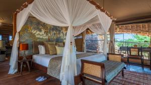 a bedroom with a bed with a canopy at Soroi Larsens Camp in Buffalo Springs  National Reserve +31 photos