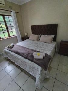 a bedroom with a large bed with two towels on it at Montreux in Richards Bay