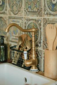 a bathroom sink with a brass faucet and a cup at KOOLNA pod kopcem in Valašské Meziříčí +25 photos