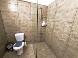a bathroom with a toilet and a glass shower at Petalmo City Apartments in Larnaca +54 photos