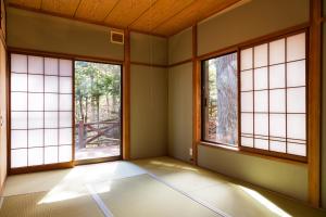 an empty room with three windows in a room at -貸切別荘-源泉かけ流し温泉 あずみ野ガレージヴィラ-1日1組限定- in Azumino