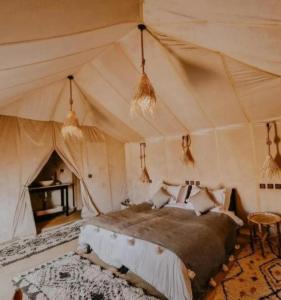 a bedroom with a bed in a tent at Tranquil gem luxury camp in Merzouga