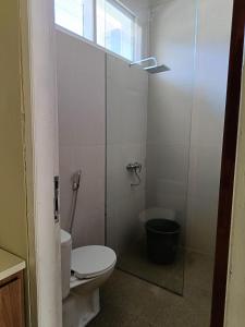 a bathroom with a toilet and a glass shower at Uciek Tengger Hotel Bromo in Ngadisari