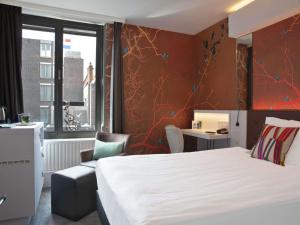 a hotel room with a white bed and a chair at Golden Tulip Hotel Central in Den Bosch +148 photos