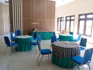 a room with green tables and blue chairs at Uciek Tengger Hotel Bromo in Ngadisari