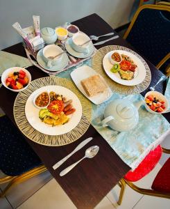 a wooden table with plates of breakfast food on it at Dreamers B&B in Maseru