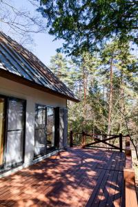 a house with a wooden deck next to a building at -貸切別荘-源泉かけ流し温泉 あずみ野ガレージヴィラ-1日1組限定- in Azumino