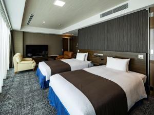 a hotel room with two beds and a television at KOKO HOTEL Premier Hakata in Fukuoka