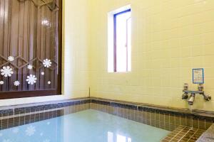 a room with a swimming pool and a window at -貸切別荘-源泉かけ流し温泉 あずみ野ガレージヴィラ-1日1組限定- in Azumino