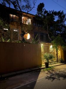 a house with a fence in front of it at night at Weaver Bird Residencies in Hewagama