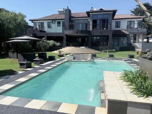 a large swimming pool in front of a house at Africa Prestige Boutique Hotel in Benoni