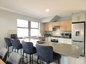 a kitchen with a large counter with chairs around it at Belo Villa Clarens in Clarens