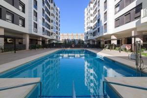 a swimming pool in an apartment complex with buildings at Maritimo Apartment in Malaga by Solaga Holiday Homes in Málaga