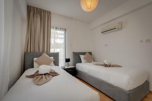 two beds sitting next to each other in a bedroom at Aphrodite Limassol Apartment in Limassol