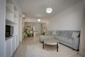 a living room with a couch and a table at Aphrodite Limassol Apartment in Limassol