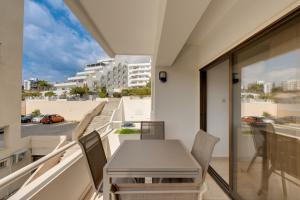 a table and chairs on a balcony with a view of a street at Aphrodite Limassol Apartment in Limassol