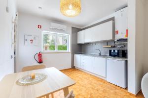 a kitchen with white cabinets and a table at Casa Paulinha in Alvor