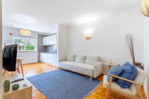 a living room with a couch and a tv at Casa Paulinha in Alvor