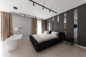 a bedroom with a large bed and a white tub at MM GROUP APARTMENT Dastor in Uzhhorod