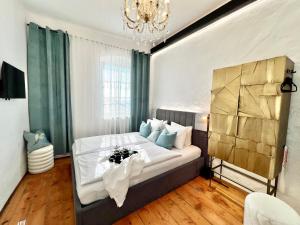 a bedroom with a bed and a chandelier at Boutique penzion U Mikuláše , Apartments Café U Rolanda in Znojmo