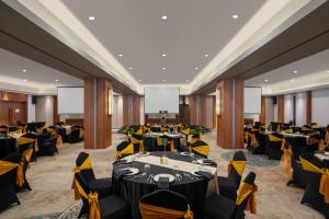 a banquet hall with black and yellow tables and chairs at The Manohara Hotel Yogyakarta in Yogyakarta +66 photos