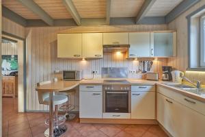 a kitchen with white cabinets and a table in it at Wildgans Classic 248 in Mirow