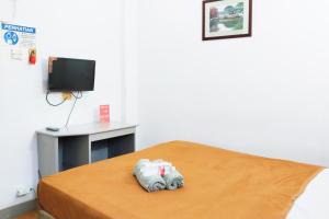 a room with a bed with a tv and a bed at NamRoom at Margot Jaksa in Jakarta