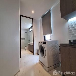 a washer and dryer in a kitchen with a bathroom at White Cube House in Nathon Bay