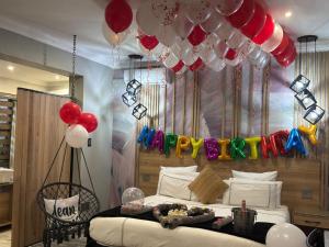 a bedroom with a bed with balloons and a bed with a bed sqor at Africa Prestige Boutique Hotel in Benoni +42 photos