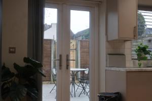 a kitchen with a sliding glass door with a table outside at Airy 3 bedroom House in Norwood