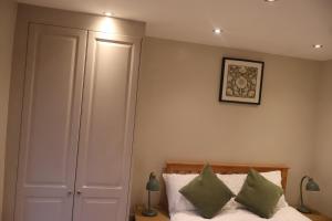 a bedroom with a bed with green pillows on it at Airy 3 bedroom House in Norwood