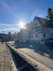 Die Sonne scheint auf eine Straße mit einem Haus in der Unterkunft Waldbach Stube in Gernsbach