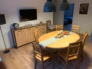 a dining room table with chairs and a television at Ferienwohnung Schimpf in Sosberg