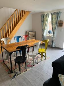 a dining room with a wooden table and chairs at Dans ma Campagne in Mecquignies