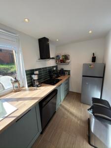 a kitchen with a counter top and a refrigerator at Dans ma Campagne in Mecquignies