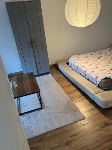 a bedroom with a bed and a table and a door at Dans ma Campagne in Mecquignies