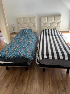 a bedroom with two beds and a bedspread with flowers at Dans ma Campagne in Mecquignies +4 photos