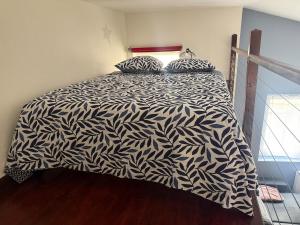 a bedroom with a bed with a black and white comforter at Studio Cardinal in Renage +3 photos