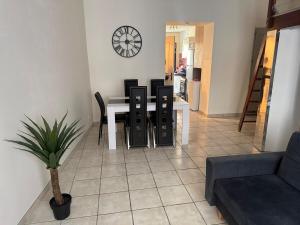 a living room with a table and chairs and a clock at Studio Cardinal in Renage