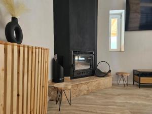 a living room with a fireplace and a tv at FurtuNest in Roşcoiu