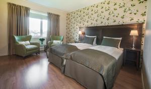 Clarion Collection Hotel Park في هالدن: غرفة نوم بسرير كبير وكرسيين
