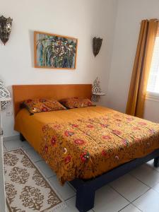 a bedroom with a bed with a colorful comforter at Residence Dar Yasmina in Mezraya