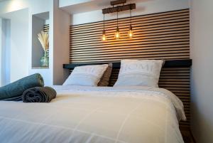 a bedroom with a large white bed with a headboard at Cocon chaleureux proche Epinal Private parking in Uxegney