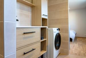 a laundry room with a washer and dryer at Cocon chaleureux proche Epinal Private parking in Uxegney