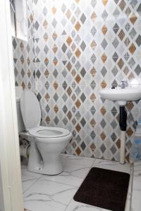 a bathroom with a toilet and a sink at Elclassico Villa in Nyanda