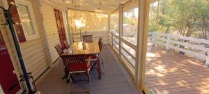 a porch with a wooden table and chairs on it at La Cabane de Nell in Lège-Cap-Ferret
