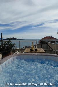 a hot tub available on a patio with a view of the water at Apartment & Room Lady O in Dubrovnik