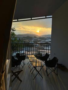 a table and chairs on a balcony with a sunset at 1909 Home Dalat - Open 24h in Ấp Kim Thạch