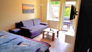 a living room with a couch and a bed and a table at Ostwind in Hohenfelde